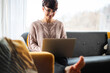© leszekglasner - Relaxed woman using laptop sitting on sofa home