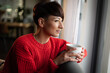 © leszekglasner - Focusing woman thinking about plans on sofa at home with cup of coffee