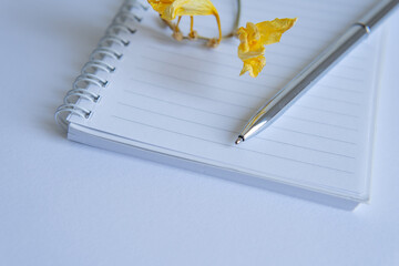 Wall Mural - close-up pen lies on a notebook with flowers on a white background