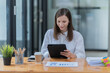 © Tj - Sharing good business news. Attractive young businesswoman talking on the mobile phone and smiling while sitting at her working place in office and Checking document.