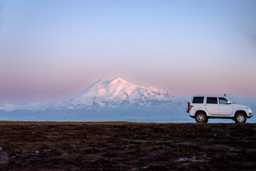 White car in fron of snow mountain