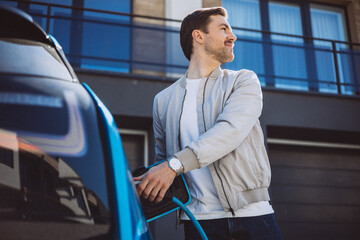 Man holding charger from his electric car