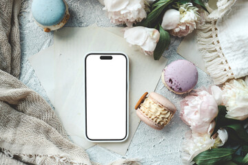 Wall Mural - Phone with an isolated screen with a place for your advertising, macaroons and peonies