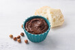 Vegan chocolate paste with banana and nuts on a light gray background