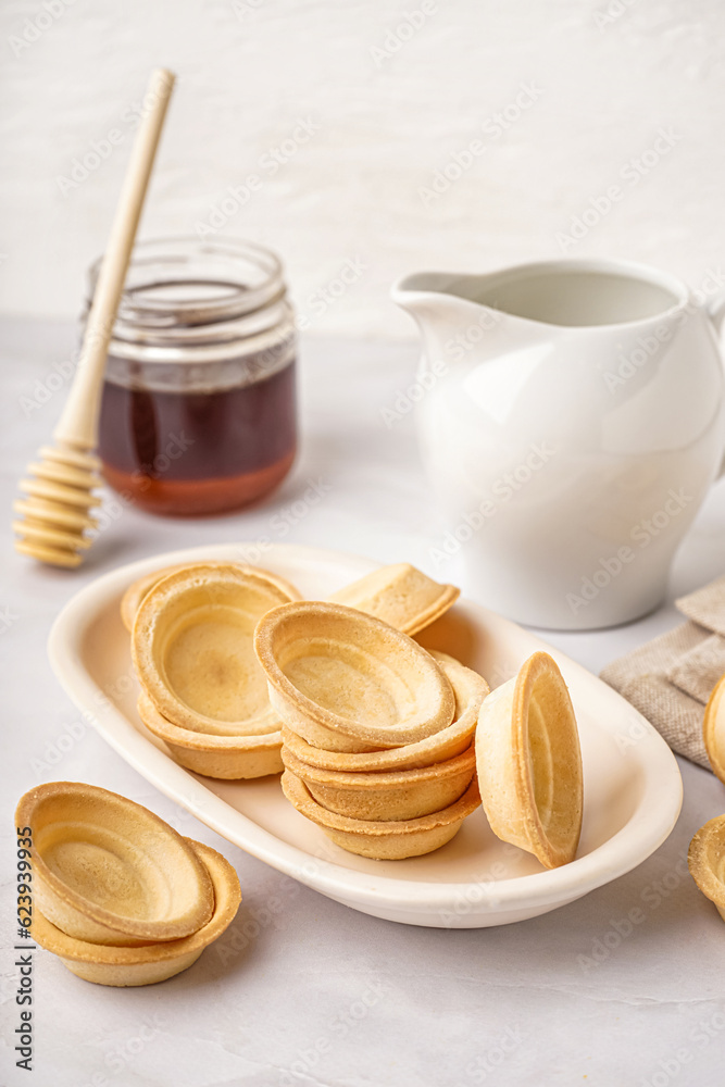 Bowl with homemade tartlets on grey background