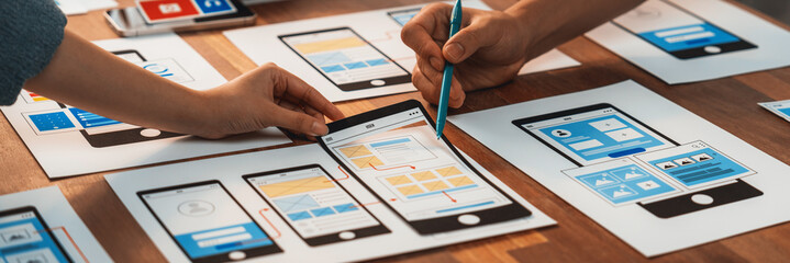Poster - Panorama shot of front-end developer team brainstorming UI and UX designs for mobile app on paper wireframe interface. User interface development team planning for user-friendly UI design. Scrutinize