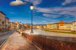Pisa, Arno river, lamp and building facades reflection. Lungarno view. Tuscany, Italy, Europe.