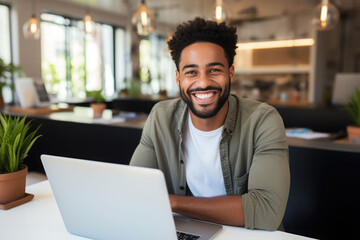 Smiling of young black freelancer use the laptop in the cafe