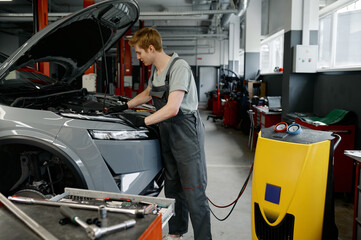 Wall Mural - Man auto mechanic entering data for refilling of car air conditioner