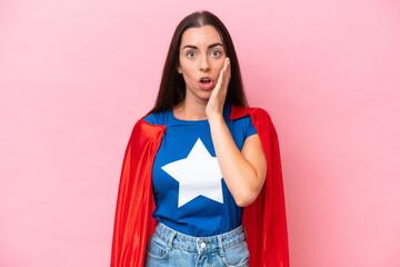 Wall Mural - Super Hero Caucasian woman isolated on pink background surprised and shocked while looking right