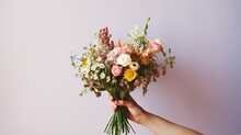 A Close-up Of A Bride's Hand Holding A Delicate Bouquet Of Wildflowers, Featuring A Mix Of Vibrant Blooms And Natural Foliage, Against A Clean And Minimalistic Background. Generative AI. 