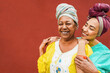 Happy african mother and daughter wearing traditional clothes - Motherhood, ethnic cultures and family concept - Focus on mum face