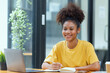 © SOMKID - Happy smiling young African American businesswoman.