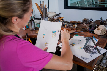 Young female jeweler making jewelry in workshop