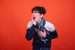 Young attractive emotional guy with health problems posing in the studio on an orange background.