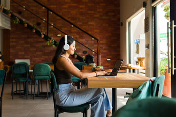 Wall Mural - Smart young woman using the internet zone working at a cafe