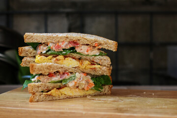 Wall Mural - Sandwich with salmon, egg, cheese and vegetables on wooden table