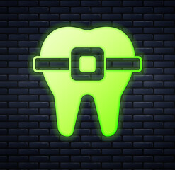 Poster - Glowing neon Teeth with braces icon isolated on brick wall background. Alignment of bite of teeth, dental row with with braces. Dental concept. Vector