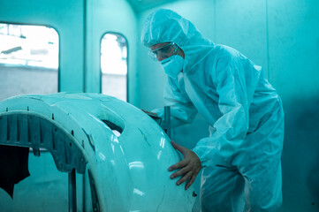 Wall Mural - Caucasian man is cleaning car parts before spraying color in repair mechanic painting shop