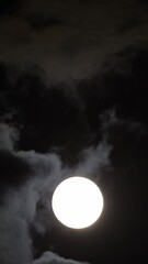 detailed image of the full moon. full moon against the black night sky. the clouds pass in front of 