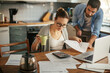 © Geber86 - Young couple going over their bills at home in the kitchen