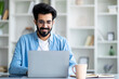 © Prostock-studio - Smiling young indian man working on laptop at home office