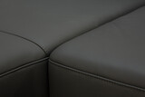 Fototapeta  - Corner sofa made of leather. Photograph of details in an interesting light