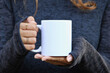 © Gravity Digital - Girl is holding white mug in hands. Blank 11 oz white cup