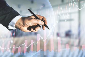 Poster - Multi exposure of businessman hand with pen working with virtual creative financial graph and world map on blurred office background, forex and investment concept