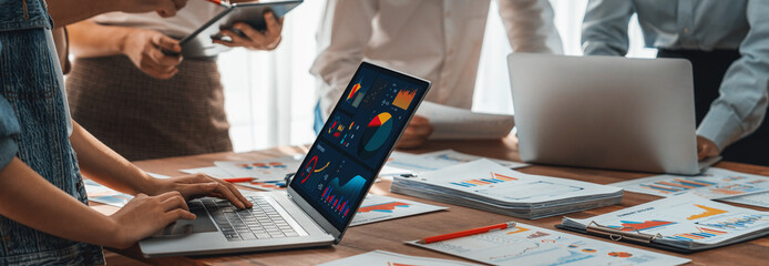 Fototapete - Panorama shot analyst team utilizing BI Fintech to analyze financial report with laptop. Businesspeople analyzing BI power dashboard displayed on laptop screen for business insight. Scrutinize