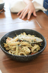 Wall Mural - Seafood Spaghetti pesto sauce with shrimp, squid and shell on wooden table. Tasty appetizing pasta .Copy space. Top view.