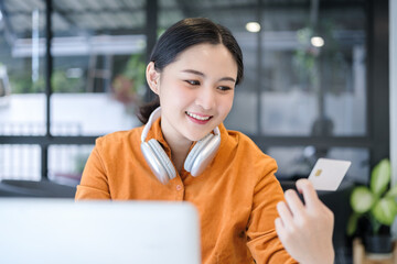 Woman hand holding credit cards and using laptop for shopping online.