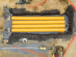 Yellow underground storm water detention mitigation units on a construction site ready to be covered.  Abstract rounded shape.
