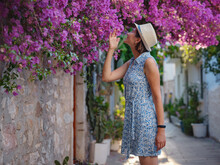 Blooming Bougainvillea, Streets Of The Old Town Of Bodrum, Turkey. Happy Traveler Woman In White Elegant Outfit Walking By Romantic Streets . Summer Travelling