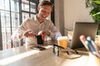 © Westend61 - Happy businessman sharpening pencil with sharpener at desk