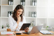 © Nuttapong punna - businesswoman working in the office with working notepad, tablet and laptop documents .