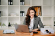 © Nuttapong punna - Beautiful woman using laptop and tablet while sitting at her working place. Concentrated at work..