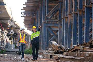 road construction engineer talking to civil engineer to supervise new road construction and inspect site at construction site