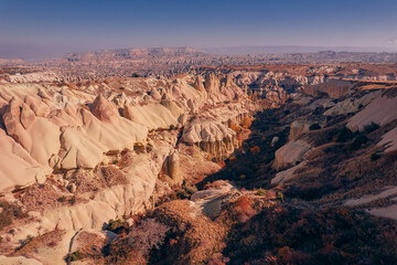 Wall Mural - Panoramic view of Goreme national park with over deep canyons, valleys sunset Cappadocia. Popular Turkey touristic destination, aerial top view drone