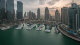 Fototapeta  - Luxury yacht bay in the city aerial night to day timelapse in Dubai marina
