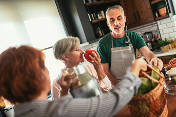 Happy mature middle-aged woman brings fresh vegetables and milk from country to her friends to make healthy dinner