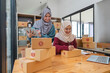 © Natee Meepian - Muslim two woman freelancer sme business online shopping working on laptop computer and checklist order box at home Business online shipping and delivery concept