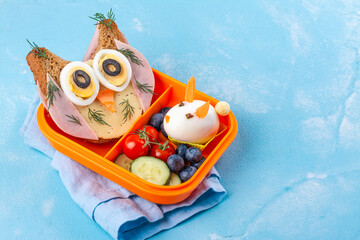 Wall Mural - Funny owl sandwich with cheese and ham and egg in shape of rabbit. School lunch box for kids. Top view. Copy space