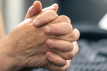 Wall Mural - The hands of an elderly woman folded in prayer.