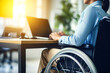 Woman with paralyzed legs in a wheelchair sitting at a computer, close up