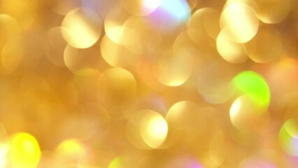 Wall Mural - A natural effect of shimmering gold bokeh lights. Blurred glitter sparkling circles motion. Bright abstract moving background in 4K resolution.