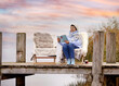 ältere Frau genießt Zeit im Liegestuhl am See