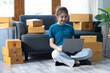 © Wasan - Young woman prepare boxes for delivery and start a small home business.