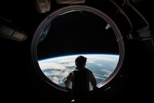 Astronaut Stand Near Round Window With View On Earth In Space Station In Space