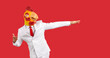 Funny humorus man in rubber mask rooster having fun dancing isolated on red background. Young man in formal white suit with comic mask on his head stands near copy space. Advertising. Banner.